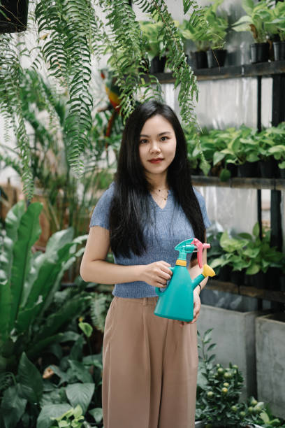 istock Asian beauty watering plants at home 2038103119