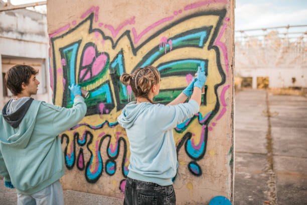 istock Back view of two artists drawing graffiti and creating their art 2038110182