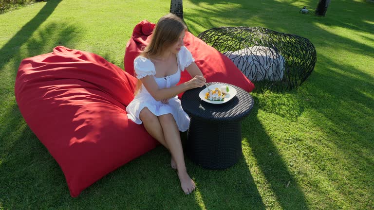 Woman in white summer dress enjoying meal outdoors