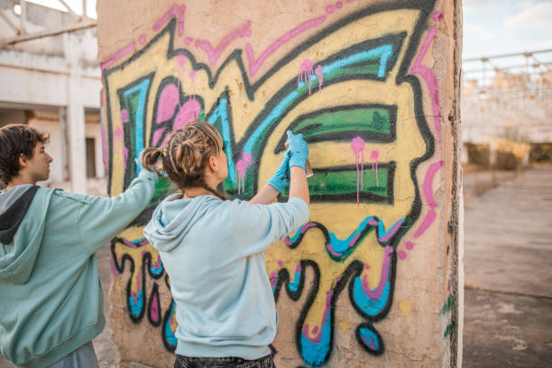 istock Back view of two street artists drawing graffiti and creating their art 2038112373