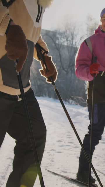 Senior Man Putting on Cross-Country Skis for Sunday Trip with Wife