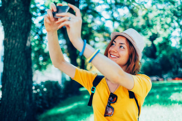istock Young woman in the park taking selfie 2038120407