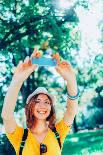 istock Young woman in the park taking selfie 2038120975