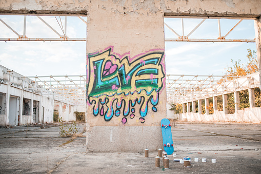 Colorful graffiti drawn on the wall of an abandoned building, during the day - The concept of love