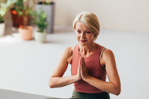 istock Senior Woman Practicing Yoga in Bright Room with Serene Expression 2038149004
