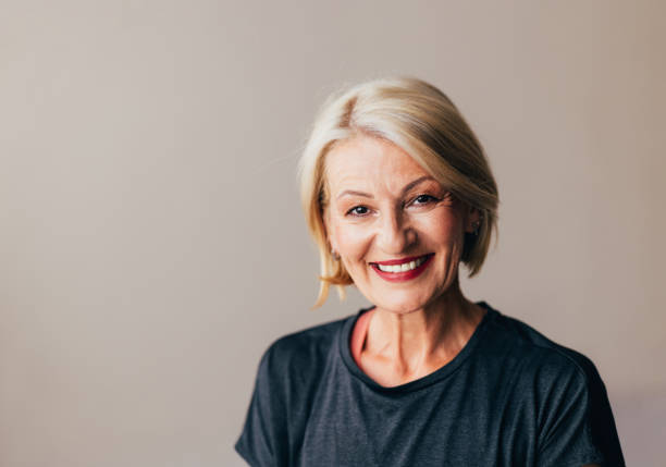 Portrait of an attractive smiling senior woman with a friendly expression, radiating confidence and positivity.