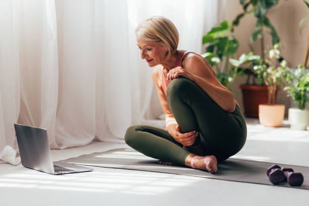 istock Senior Woman Practicing Yoga at Home, Following Online Class 2038149018