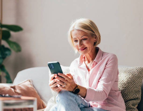 istock Smiling Senior Woman Enjoying Technology at Home on Sofa 2038149599