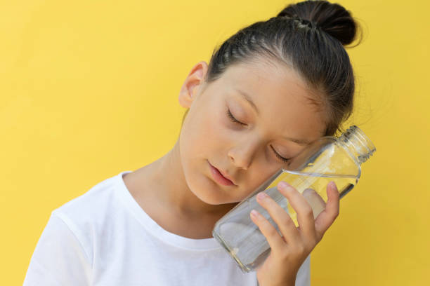 Little girl having water break on the beach to avoid dehydration and heat illness. Concept of keeping children hydrated and safe during a heatwave