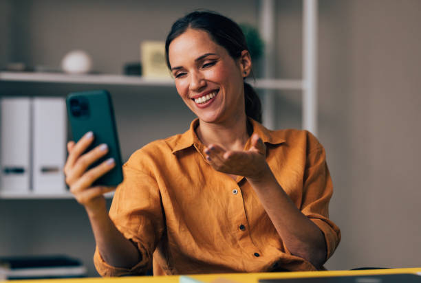 istock Smiling Woman Having Video Call on Smartphone Indoors 2038157631