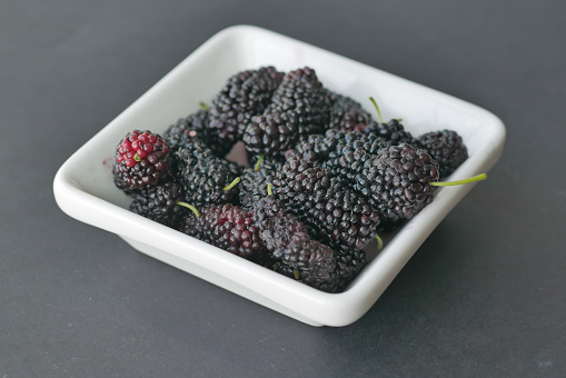 fresh Blackberry in a white bowl on table .