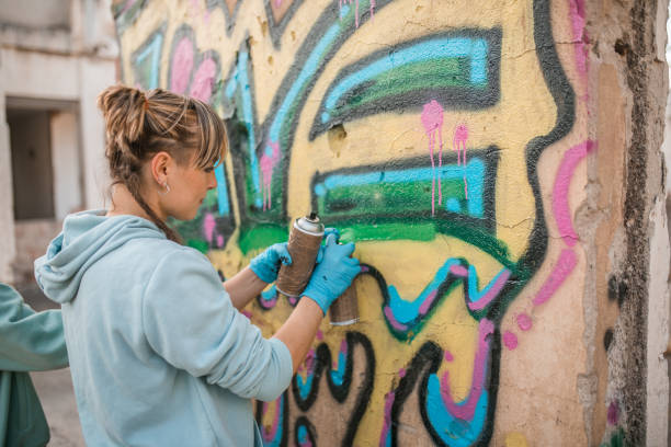 istock Woman draws colorful graffiti on the wall and creates her art 2038180073