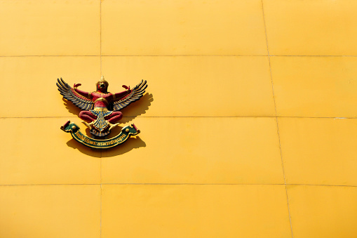Emblem of Thailand, Thai Coat of Arms - Phra Khrut Pha - representation of the Garuda  mythical bird, used by the God Vishnu to fly. The motto is in the Pali language written in Thai script: 