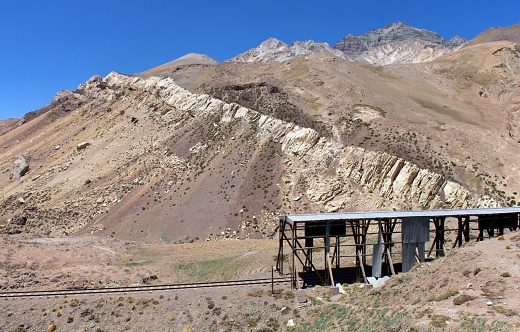 Mendoza, Argentina, November 15, 2019: View of the Argentinian Andes and the abandoned railway above the Mendoza River Valley on a sunny morning.