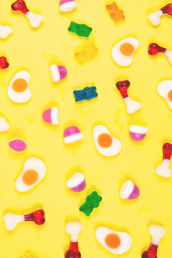 Assorted jelly sweets on yellow background. Pattern.