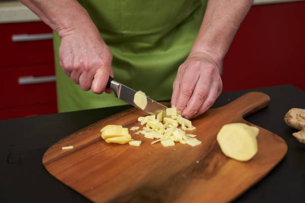 istock Man chopping ginger on a wooden board 2038216656
