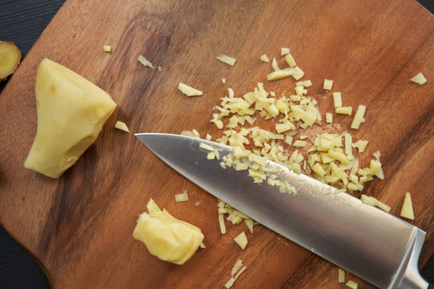 istock Man chopping ginger on a wooden board 2038216657