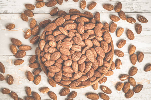 Fresh natural healthy almonds nuts on a wooden plate