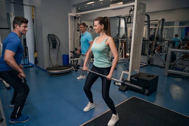 istock Fit couple working out with gym instructor 2038269504