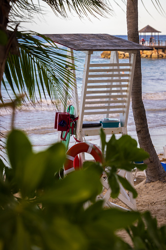 A lifeguard chair sits underneath palm trees in Jamaica