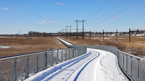 The boardwalk trail after snow in winter at Russell Peterson Wildlife Refuge near Wilmington riverfront, Delaware