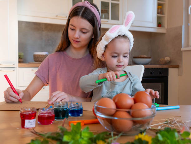 istock Easter egg coloring sisters play and enjoy 2038292784