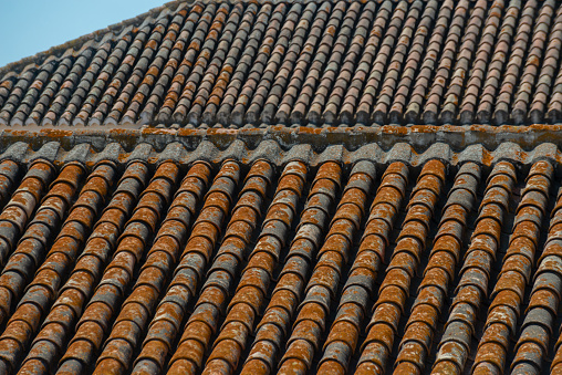 Traditional old Spanish ceramic roof tiles on a building, characteristic elements of Mediterranean architecture, vintage