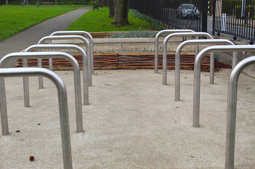 A photo of a group of bike parking metal racks lined up together on a path.