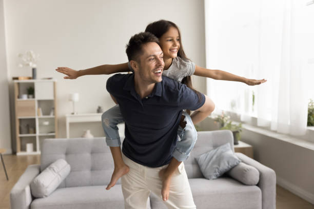 istock Cheerful playful daughter kid playing airplane with daddy at home 2038326167