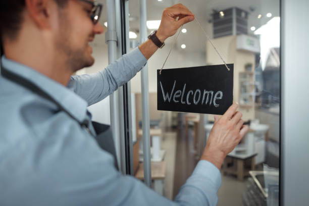 Young handsome man putting welcome message on doors