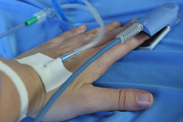 pacjentka w łóżku z dostępem dożylnym czujnik pulsoksymetru w dłoni. zbliżenie na złącze do infuzji dożylnej - acess zdjęcia i obrazy z banku zdjęć
