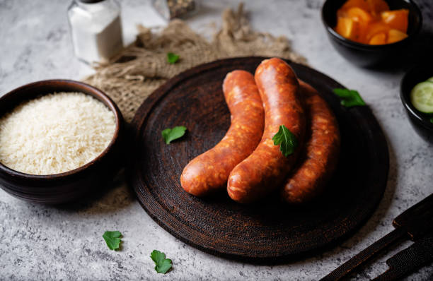 istock Raw uncooked sausages Chorizo on a wood board 2038343648
