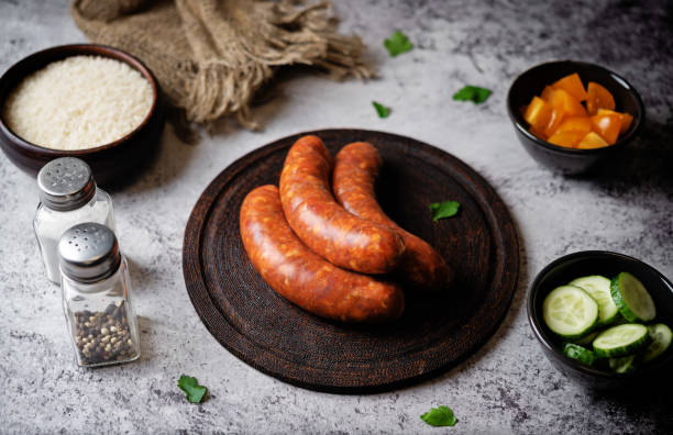 istock Raw uncooked sausages Chorizo on a wood board 2038343679