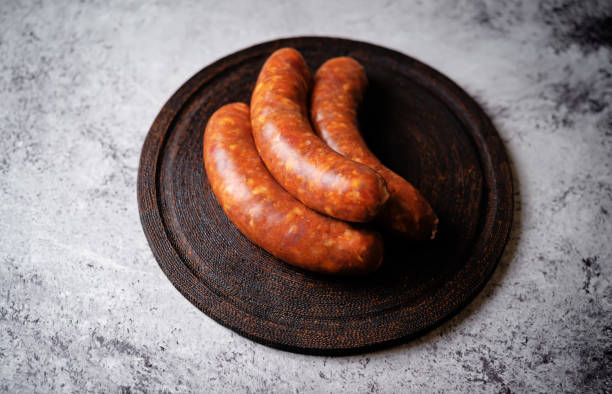 istock Raw uncooked sausages Chorizo on a wood board 2038343691