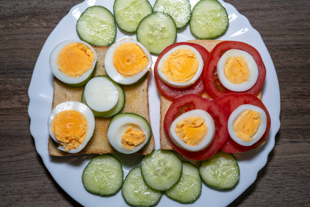 Toast bread with eggs, tomatoes and cucumber slices in a white plate
