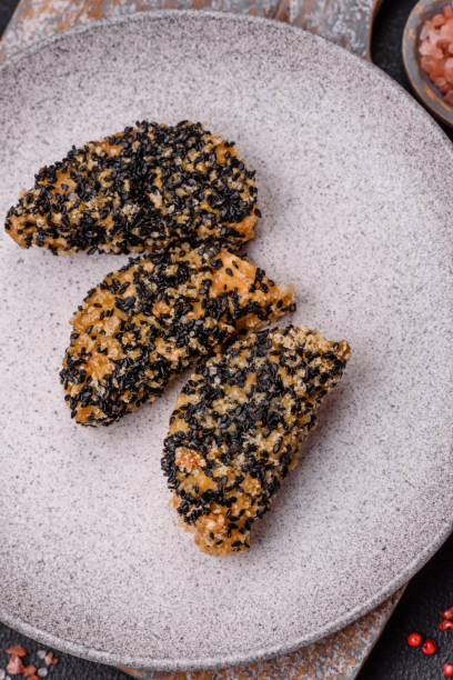 istock Delicious fresh crispy chicken or fish nuggets on a dark concrete background 2038344204