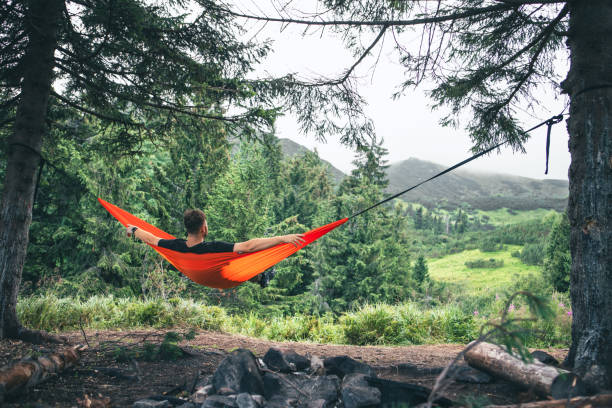 istock man in hammock at camping site mountains on background 2038344251