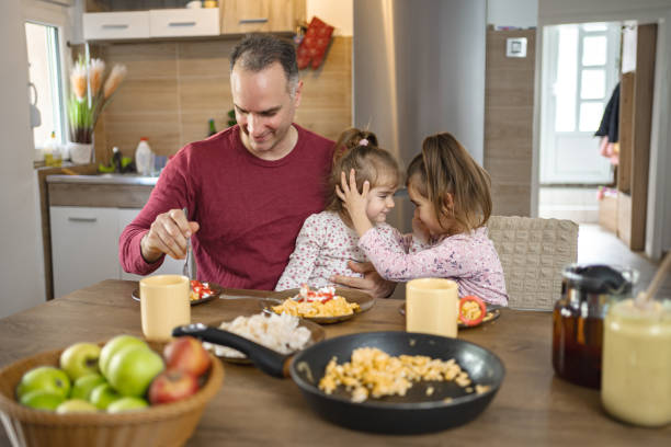 istock Father having breakfast with his two daughters at home 2038362045