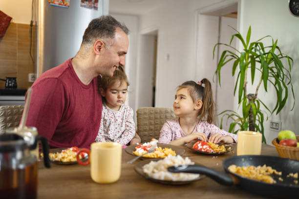 istock Father having breakfast with his two daughters at home 2038362568