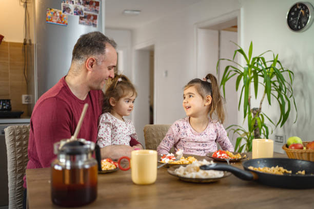 istock Father having breakfast with his two daughters at home 2038362569