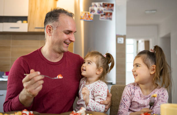 istock Father having breakfast with his two daughters at home 2038363087