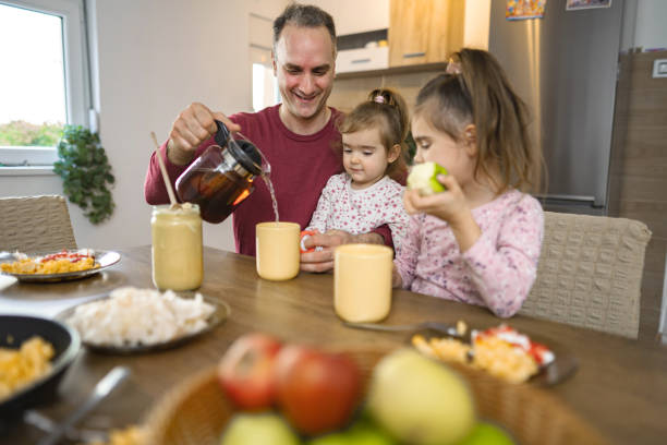istock Father pouring tea for his daughters at home 2038363649
