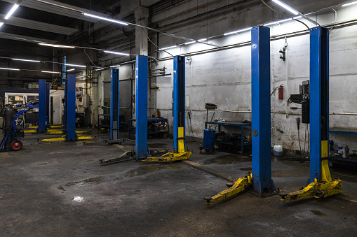 Empty concrete car service interior with vacant car lifts