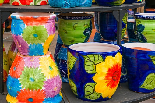 Stacks of brightly painted flower pots in a retail display.