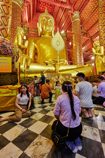 Ayutthaya, Thailand - August 26, 2023: people pray in front of Thailand largest Buddha statue known as Luang Po To. Phanan Choeng temple.