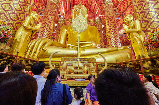 Ayutthaya, Thailand - August 26, 2023: people pray in front of Thailand largest Buddha statue known as Luang Po To. Phanan Choeng temple.