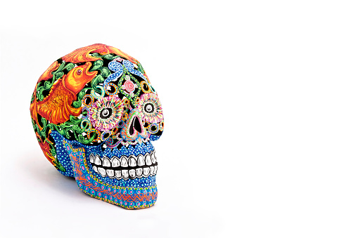 Colored skulls, Mexican crafts. Day of the Dead, Handmade multicolor figure, white background