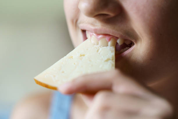 istock Crop happy unrecognizable girl biting fresh cheese slice 2038440820