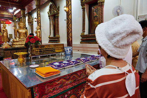 Phrae, Thailand - February 13, 2014: Buddhist monk and woman praying at Wat Luang in Phrae, Thailand.