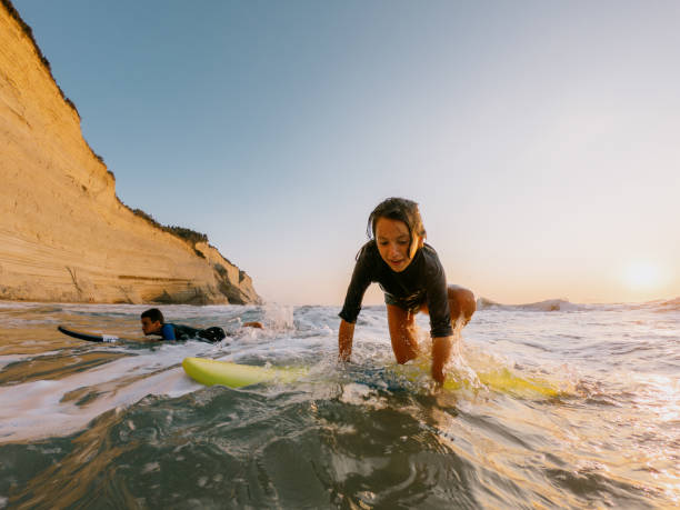 teenagers having an  active life surfing on the beach in the summer - surfing teenage girls friendship sunset photos et images de collection